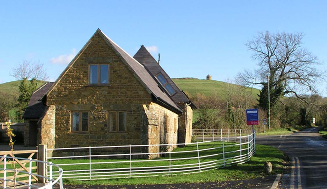 La iglesia templaria de Temple Herdewyke, convertida ahora en vivienda, con la Almenara del Fénix (‘Phoenix Beacon’) al fondo sobre la colina. (Fotografía © Graham Phillips)