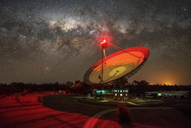 Una imagen del radiotelescopio CSIRO Parkes con un cielo nocturno estrellado de fondo.